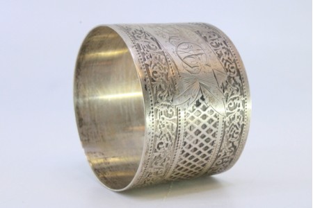  Argola de guardanapo em prata com motivos florais gravados e frisos envolvendo cartela para monograma.